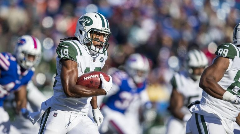 The Jets' Andre Roberts runs with the ball during a kickoff...