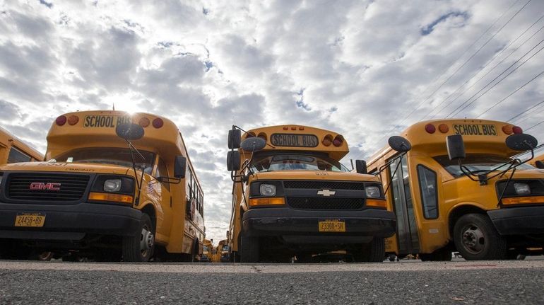 Buses owned by Ronkonkoma-based Baumann & Sons sit in a...