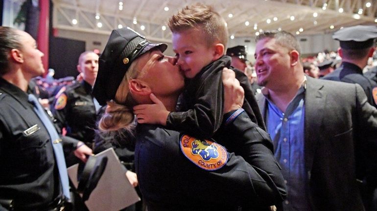 Nassau County Police Officer Dana Allimonos kisses her 3-year-old son,...