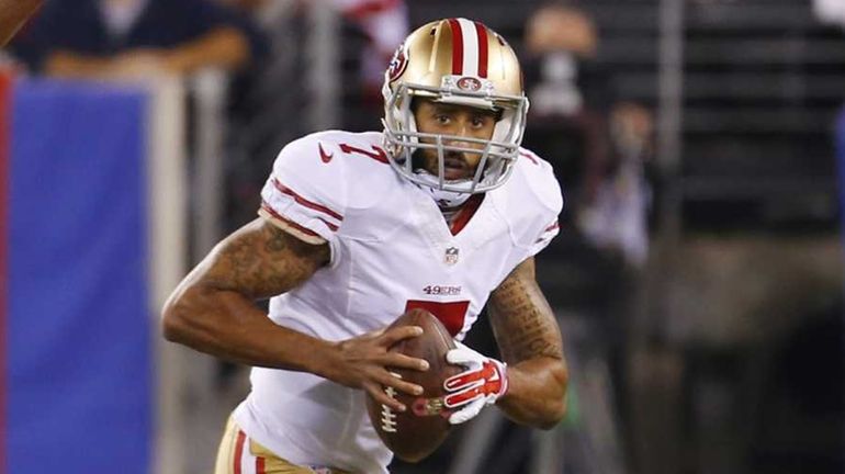 Colin Kaepernick of the 49ers scrambles out of the pocket against...