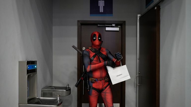 A cosplayer dressed as Deadpool attends a Comic-Con convention in...