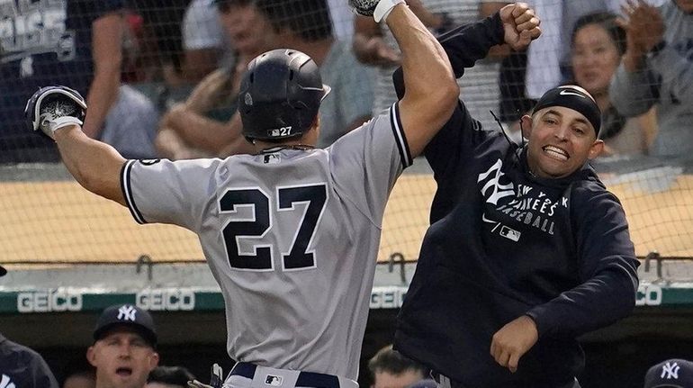 TheYankees' Giancarlo Stanton is congratulated by teammates after hitting a...