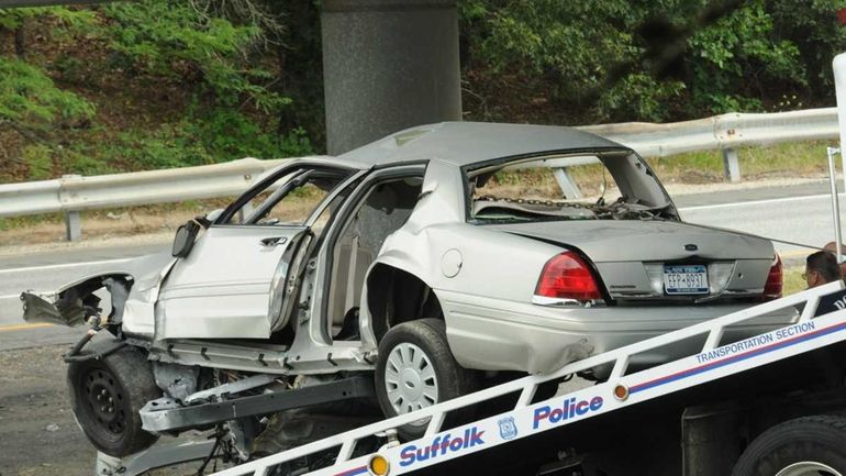 A wrecked unmarked Suffolk County police car sits on a...