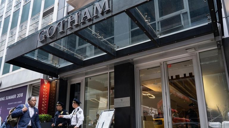 Police stand outside the Gotham Hotel in midtown on Friday,...