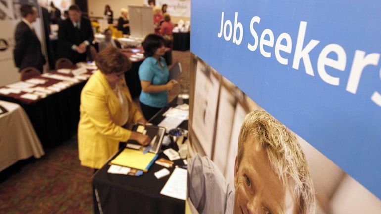 Job seekers visit recruiters at a jobs fair in Green...