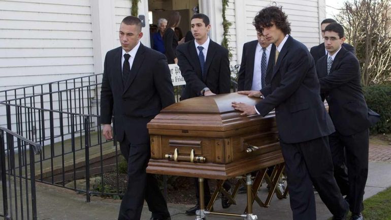 Pallbearers walk with John Romanelli's coffin at the First Presbyterian...