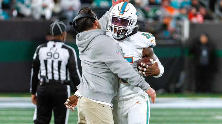 Miami Dolphins linebacker Jerome Baker (55) celebrates with linebackers coach...