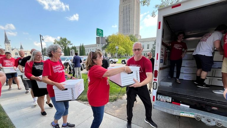 Organizers load boxes of signed petitions seeking to get a...