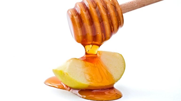 Rosh Hashanah, symbolic foods include honey and apples for a...