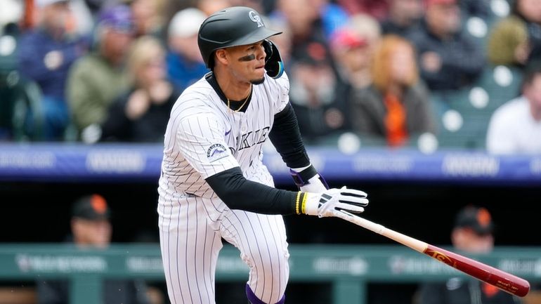 Colorado Rockies' Ezequiel Tovar heads up the first-base line with...