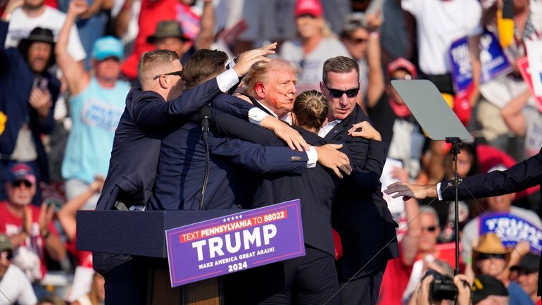 Republican presidential candidate former President Donald Trump is helped off...