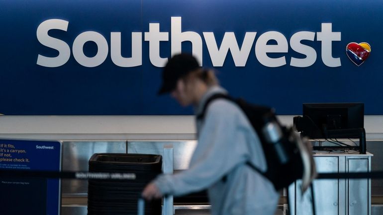 A traveler walks through the Southwest Airlines ticketing counter area...