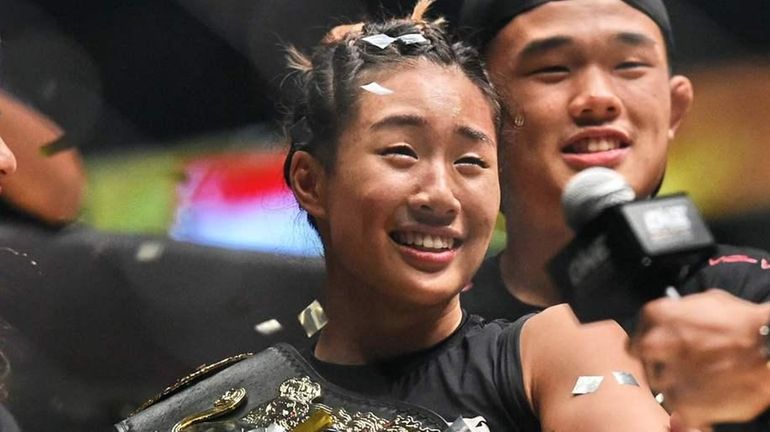 Singapore's Angela Lee (C) celebrates with family members after defeating...