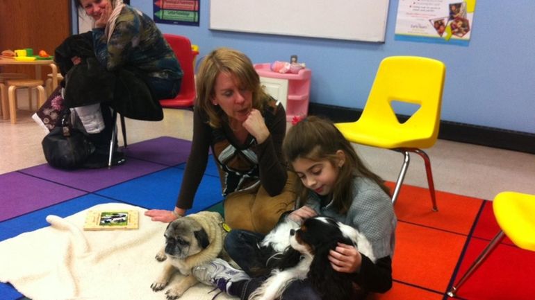 Julia Spilabotte, 9, of Melville, reads to Bella, a therapy...