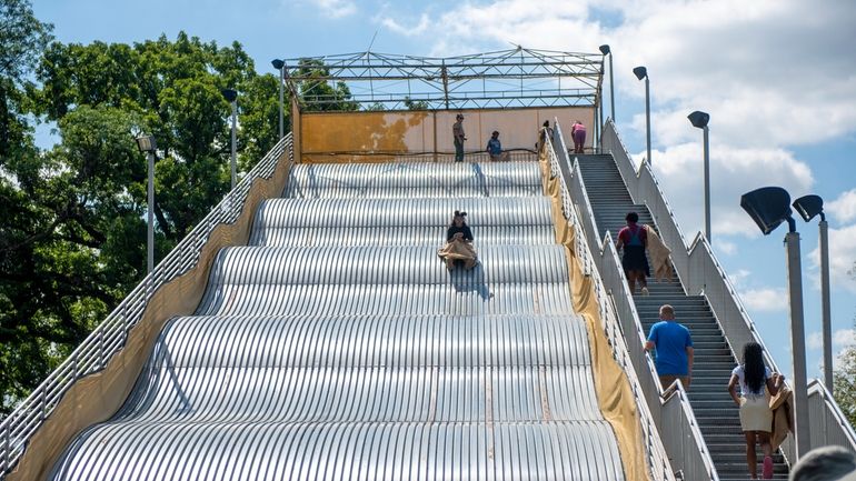 People ride the newly reopened Giant Slide at Belle Isle...