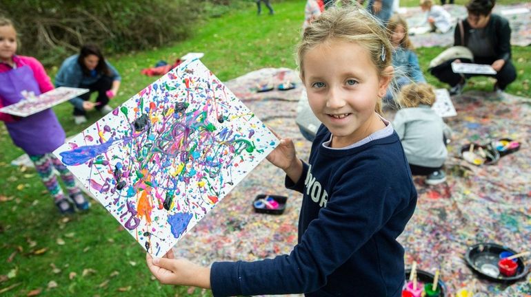 Olivia Fabe-Blados, 8, from Manhattan, attends a drip painting family...