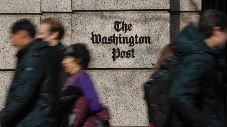 People walk by the One Franklin Square Building, home of...