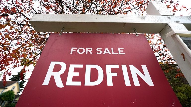 A Redfin "for sale" sign stands in front of a...