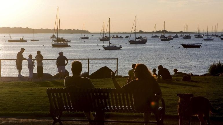 People stroll along the water in Harborfront Park in Port...