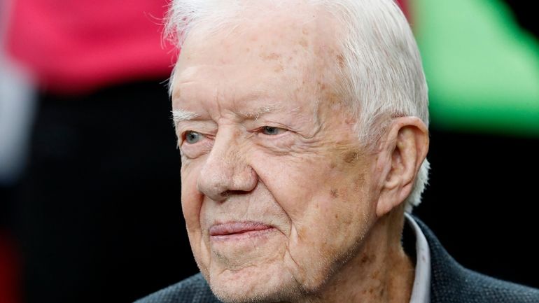 Former President Jimmy Carter sits on the Atlanta Falcons bench...