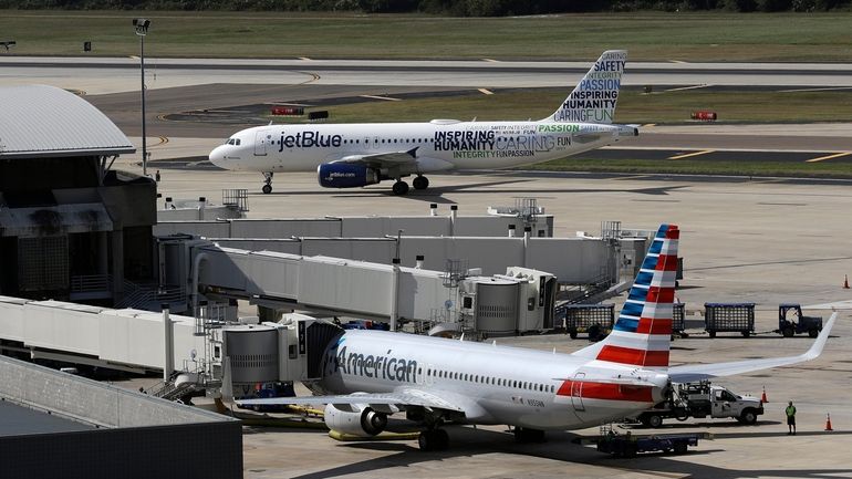 A JetBlue Airbus A320 taxis to a gate after landing,...