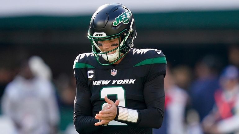 Jets quarterback Zach Wilson reacts after throwing an interception against...