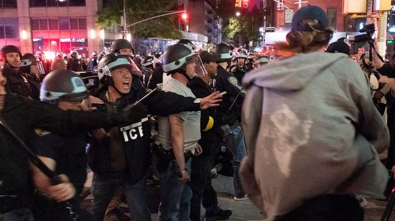 Members of the NYPD detain demonstrators on Sixth Avenue and West...