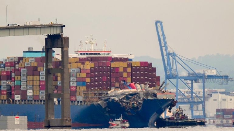 Tugboats escort the cargo ship Dali after it was refloated...