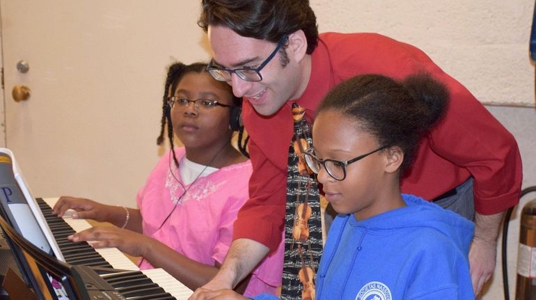 Music teacher Andrew Tilles listens to student Jordan Simpson-Fisher's performance...