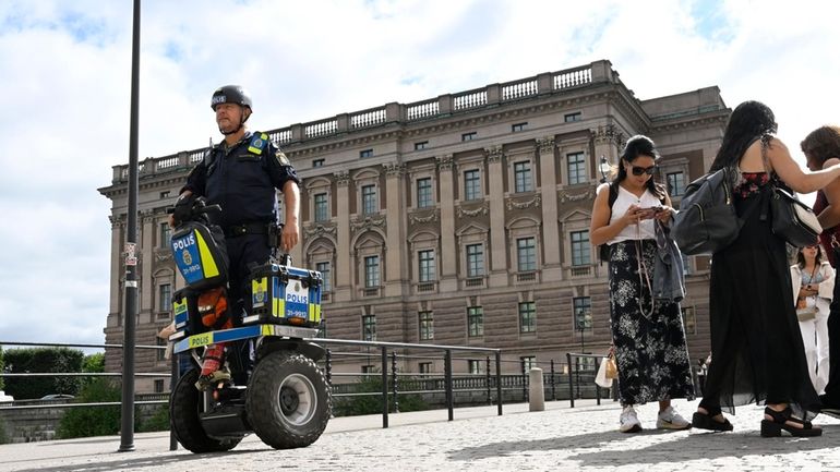 A police officer on a Segway patrols Sweden's parliament in...