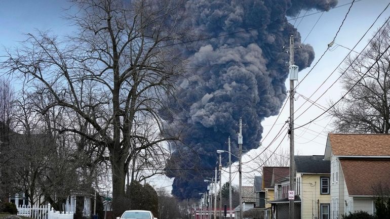 A black plume rises over East Palestine, Ohio, as a...