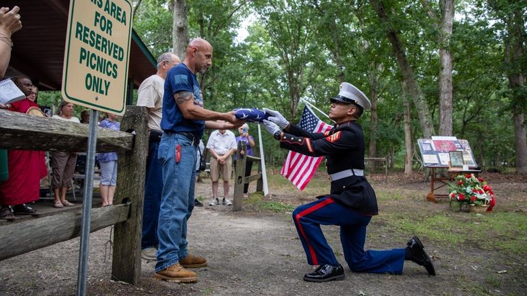 Joe Gennarelli, nephew of Ted Strickroth, receives a folded flag...