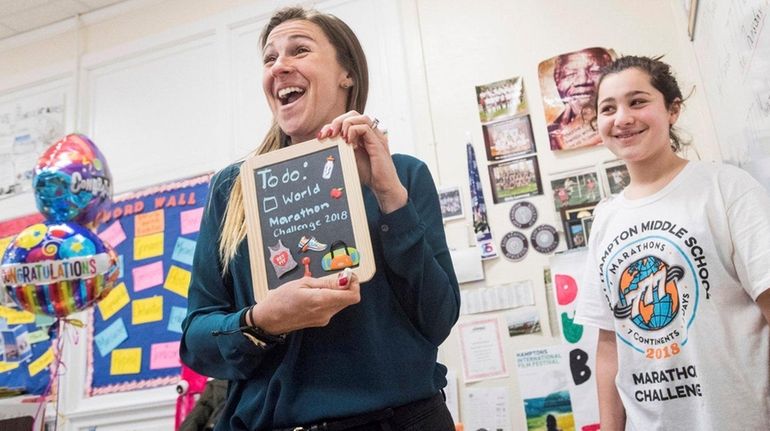 Teacher Cara Nelson shows off a present from seventh-grader Olivia...