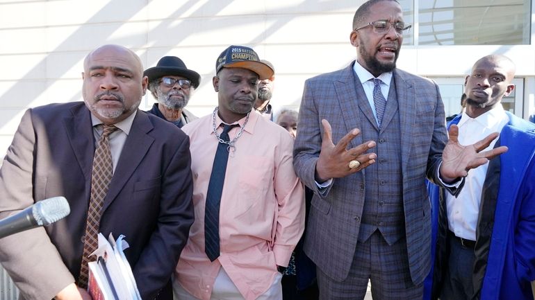 Lead civil attorney Malik Shabazz, second from right, speaks to...