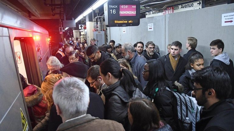 Passengers navigate past a construction wall blocking track 15 to...