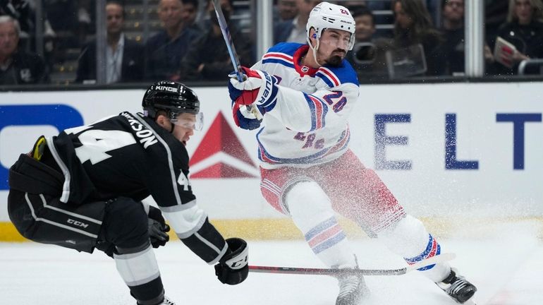 Rangers' Chris Kreider (20) shoots to score as he is...