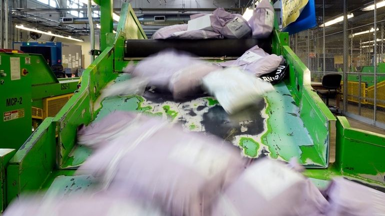 Parcels slide down a ramp after being scanned at the...