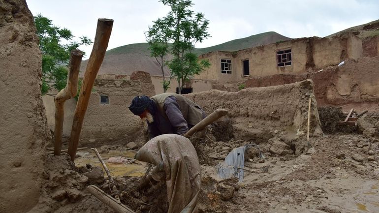 An elderly man collects his belongings from his damaged home...