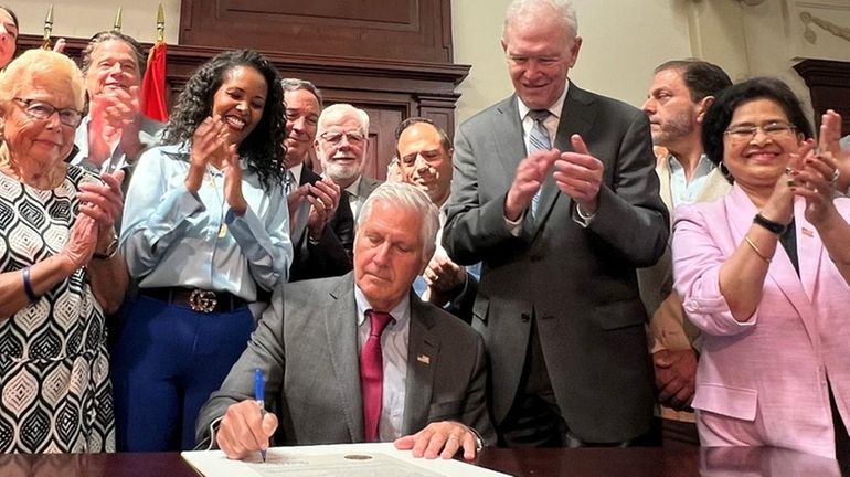 Nassau County Executive Bruce Blakeman signs the bill approved by...