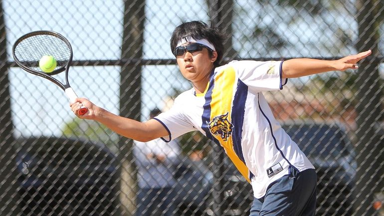 Shoreham-Wading River's Ray Hidaka returns a serve in the first...