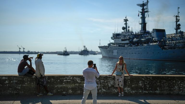 A woman poses for a photo backdropped by the Russian...