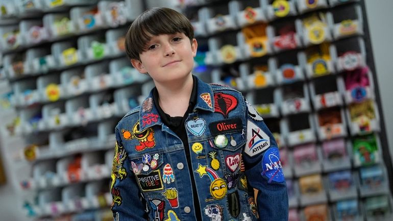 Oliver Burkhardt, 13, stands in front of trays of patches...