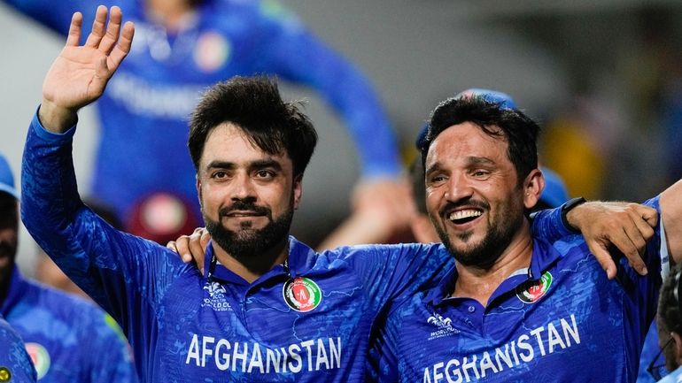 Afghanistan's captain Rashid Khan, left, and teammate Gulbadin Naib celebrate...