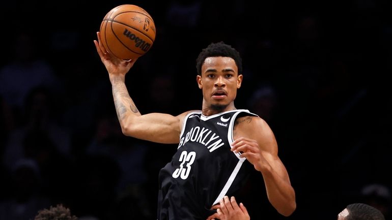 Nets center Nic Claxton grabs a rebound against Heat guard Josh...