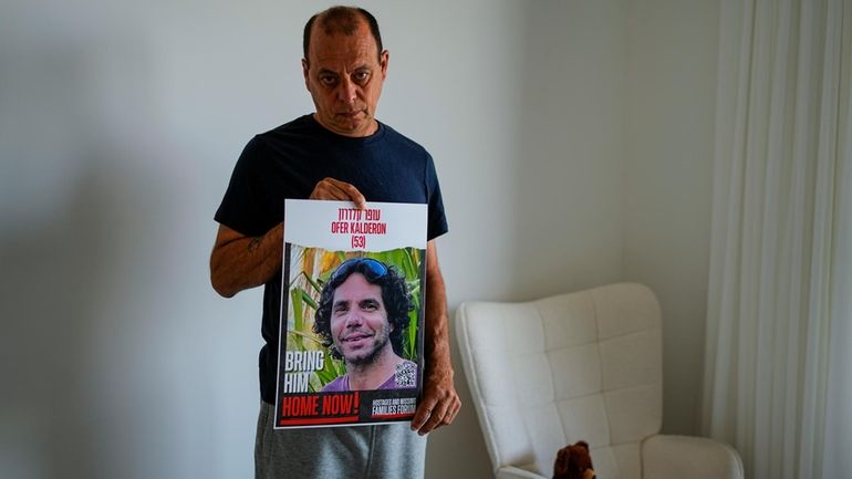 Nissan Kalderon poses with a photo of his only brother,...