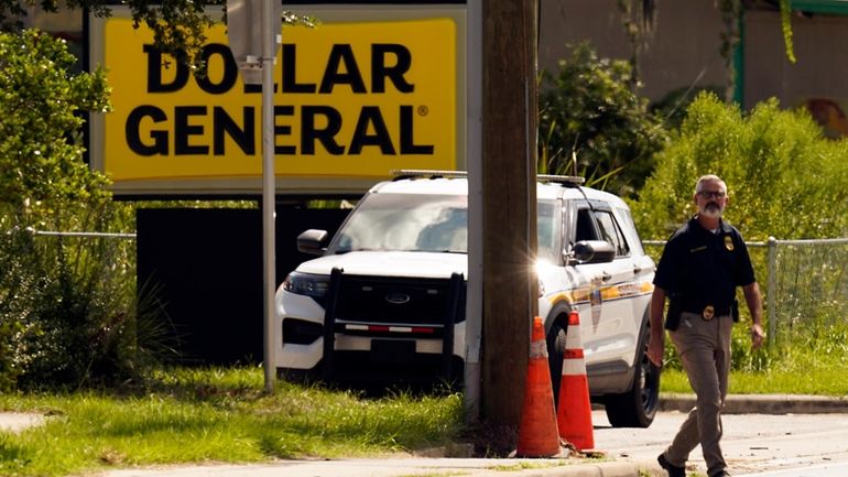 Law enforcement officials continue their investigation at a Dollar General...