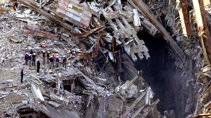 Workers survey the ruins of the World Trade Center in...