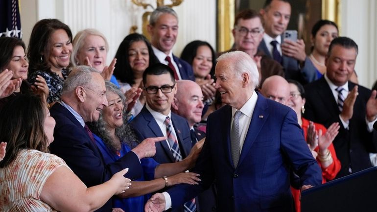 President Joe Biden turns to the others on the dais...