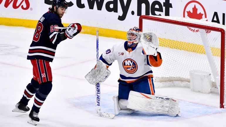 Islanders goaltender Semyon Varlamov (40) and Winnipeg Jets Kevin Stenlund...