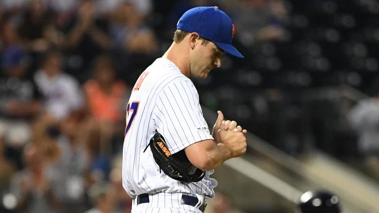 Mets relief pitcher Seth Lugo reacts on the mound as...